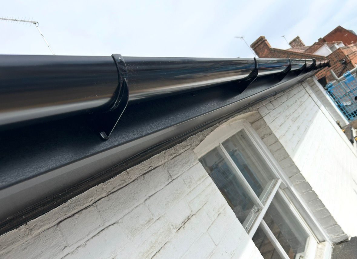 Close up of new black guttering and white soffit